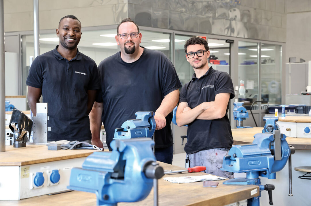 In der Ausbildungswerkstatt der „König Metall Academy“ lernen zur Zeit 40 Azubis, darunter Mandela Asseno (links) und Mert Hermantepe (rechts).  Andre Reinbold (Mitte) legt dabei Wert auf individuelle Förderung